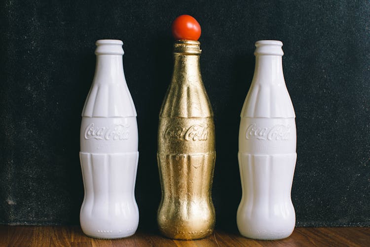 Three White And Brass Coca-cola Bottles