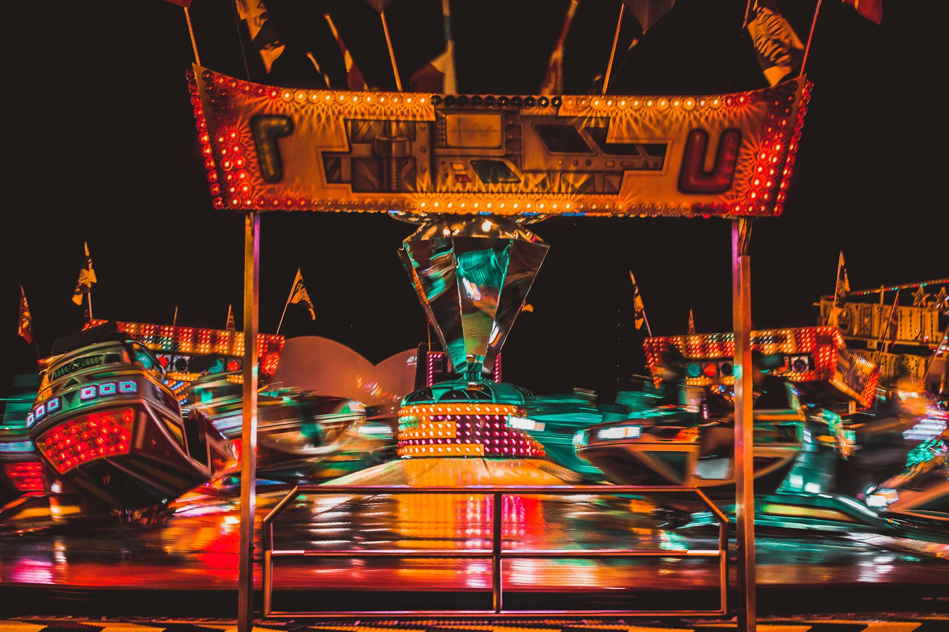 Exciting carnival scene at night in Almere showcasing vibrant neon lights and motion blur on rides.