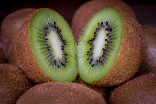 Free A vibrant close-up of a juicy, sliced kiwi showcasing its green texture and seeds. Stock Photo