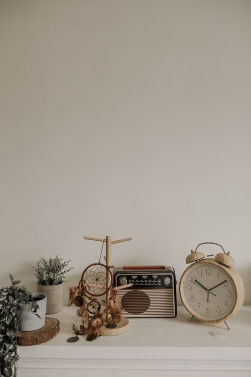 Free Elegant minimalistic arrangement with a dreamcatcher, vintage radio, clock, and plants. Stock Photo