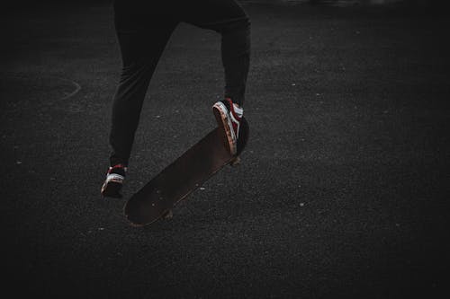 A Person in Black Pants Skating on the Street