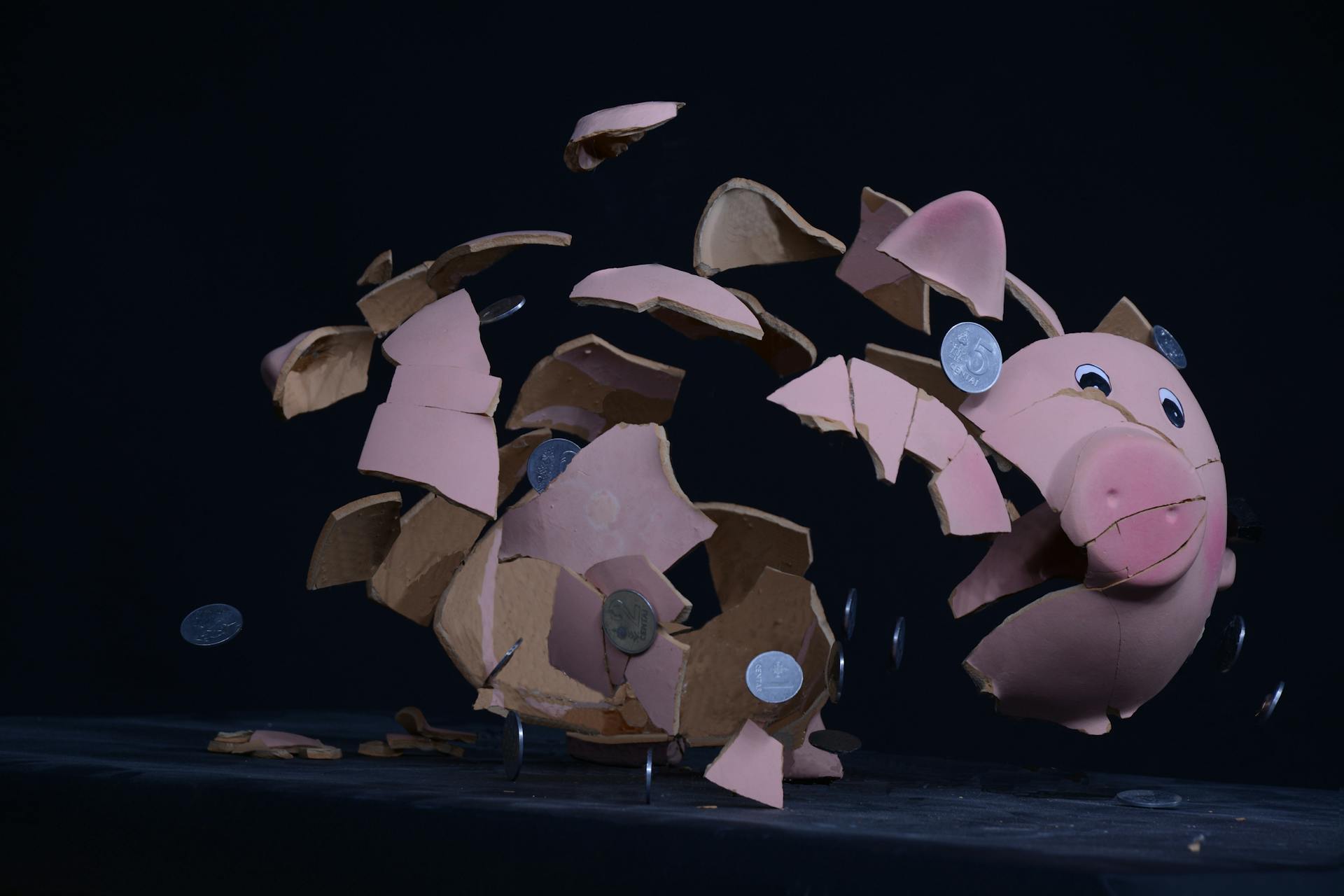 High-speed capture of a piggy bank shattering with coins scattering in mid-air.