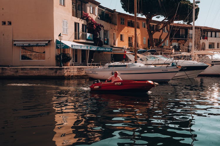  A Person Riding A Red Boat On Water