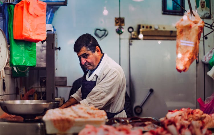 Butcher Behind Displayed Meat