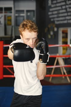 Portrait of a determined man practicing boxing indoors with focus and intensity.