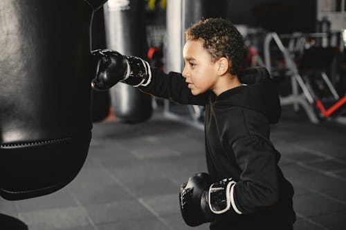 A Boy Hitting Black Punching Bag 