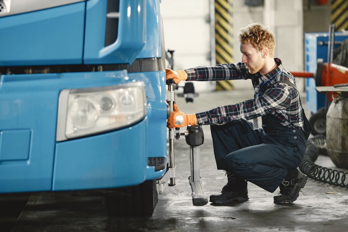 Mechanic aligning truck tires in the shop