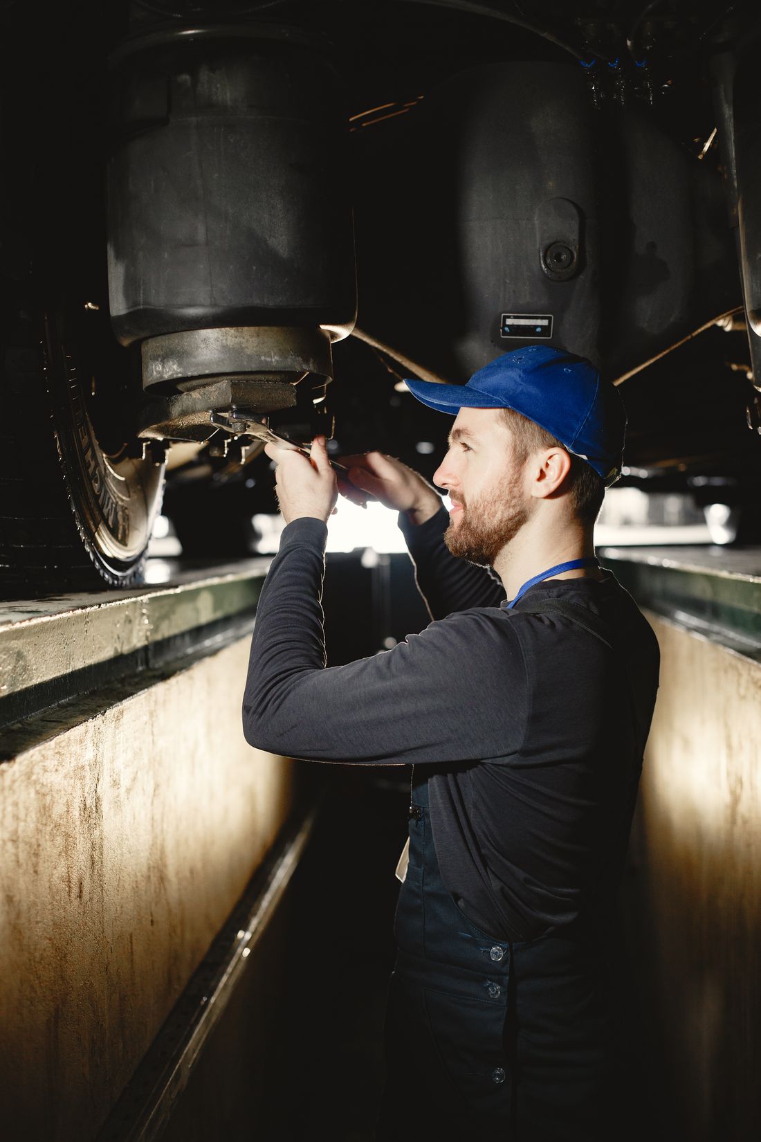 A lean mechanic in a ball cap in the shop