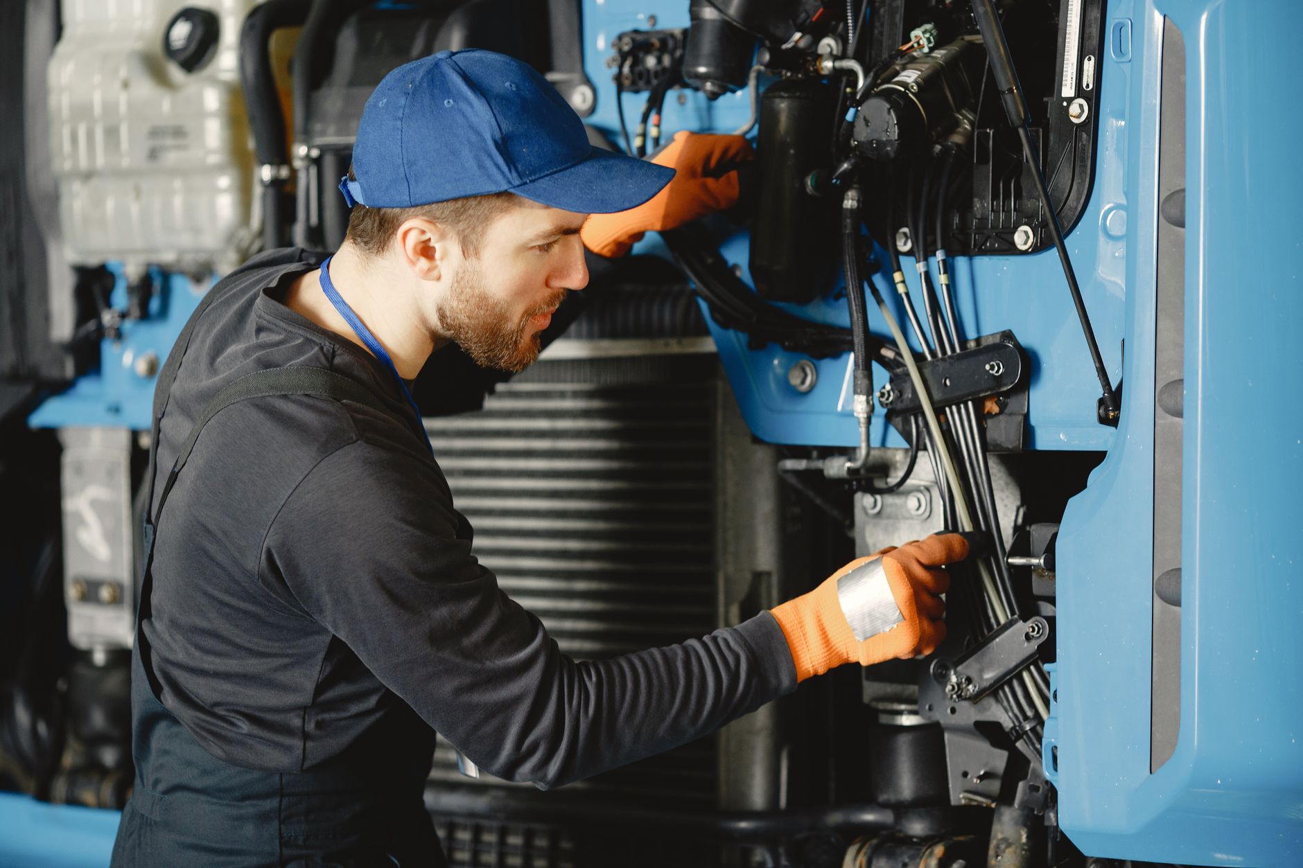 Troubleshooting Shearing Machine Hydraulic Problems插图2 Skilled worker in safety gear repairing industrial equipment.