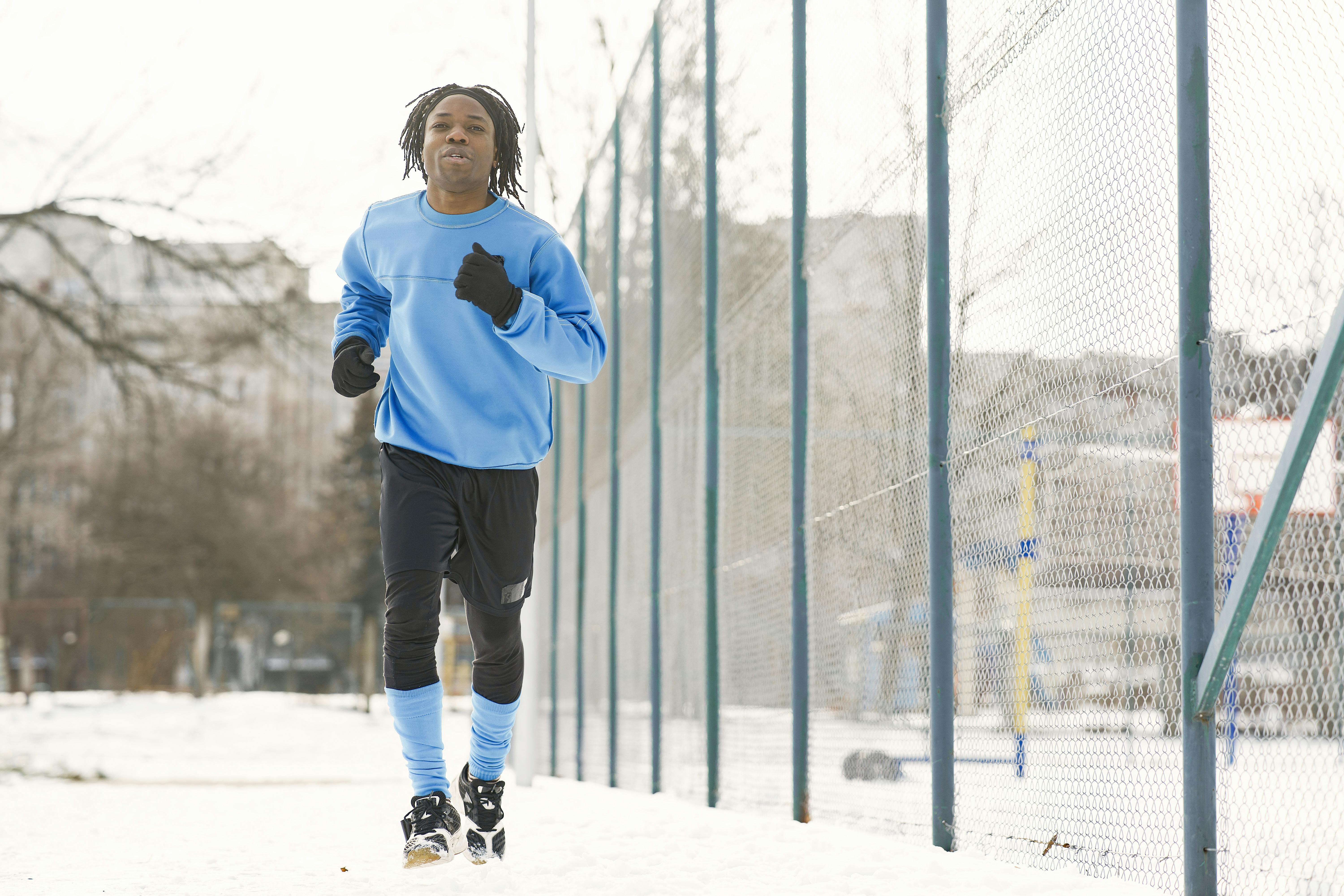 runner in winter gear on foggy morning path, layered clothing