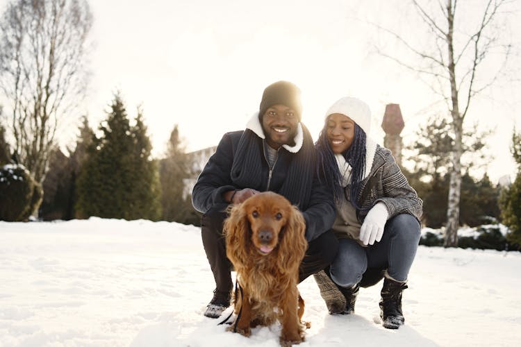 Portrait Of A Couple With A Dog On Snow