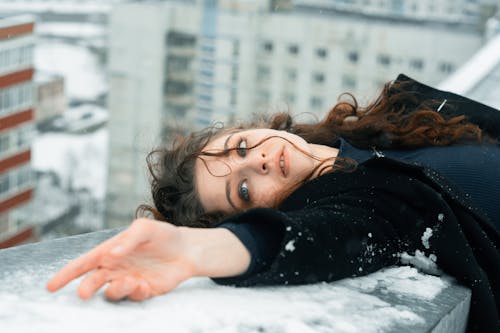 Woman Bending Backwards on the Snow on Balcony Balustrade 