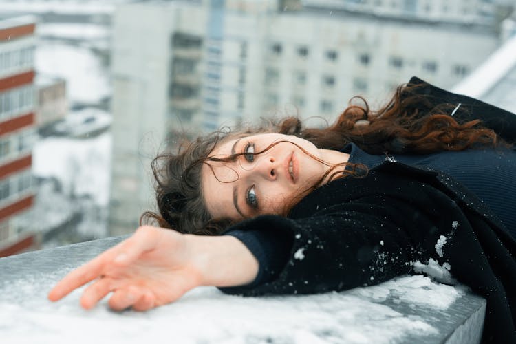 Woman Bending Backwards On The Snow On Balcony Balustrade 