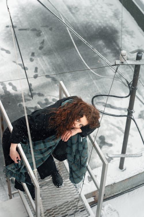 A Woman on a Steel Ladder at the Rooftop