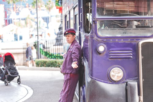 Driver in Front of a Purple Bus 
