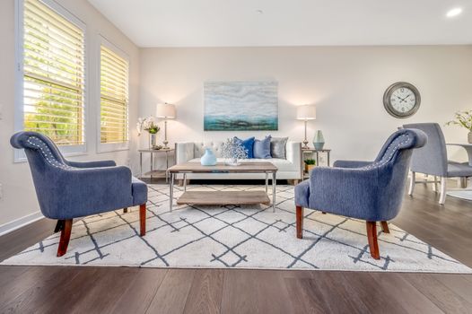 Spacious living room with stylish blue chairs and decor.