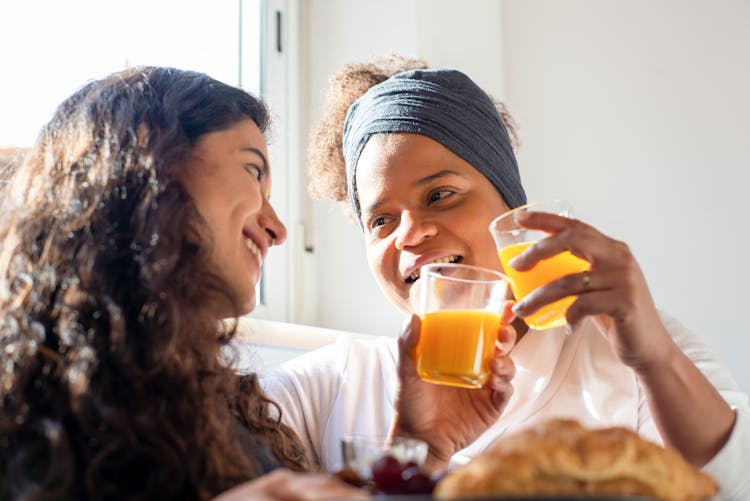 Women Clinking Glasses With Orange Juice