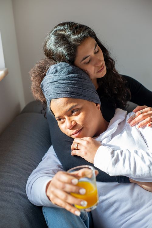 Free A loving couple enjoys a quiet morning together indoors, embracing on the sofa. Stock Photo
