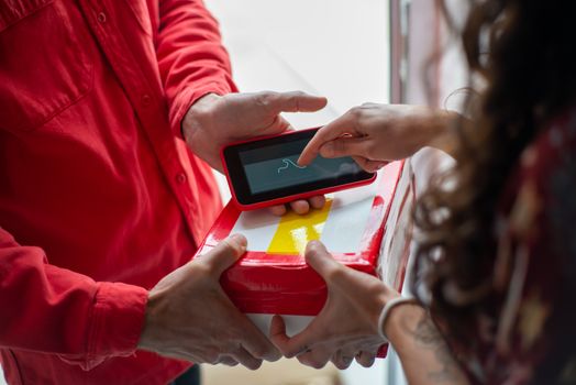 A customer signs for a package using a digital device, enhancing delivery efficiency.