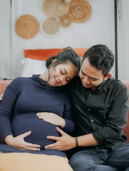An intimate and warm moment between a couple embracing pregnancy and love. - Fotografer Sidoarjo