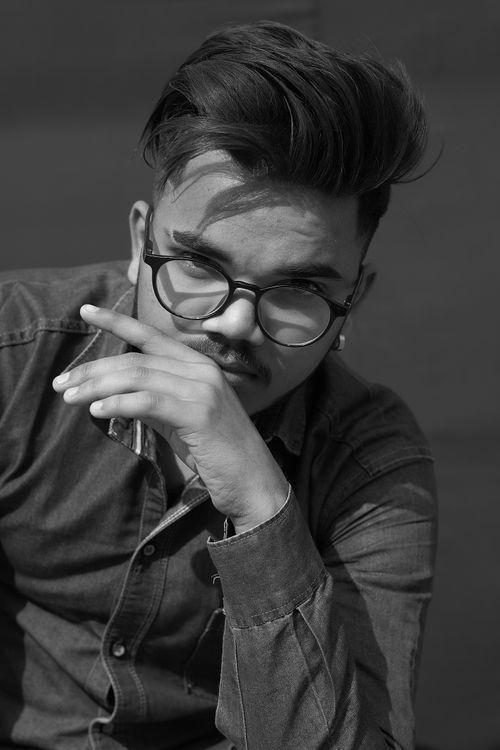Free Monochrome portrait of a man in eyeglasses, thoughtful pose, casual denim. Stock Photo