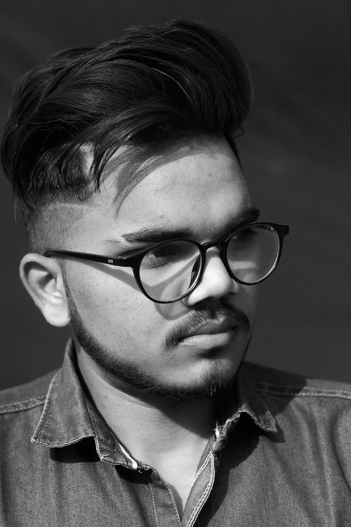 Free Black and white portrait of a young man wearing eyeglasses with serious expression. Stock Photo