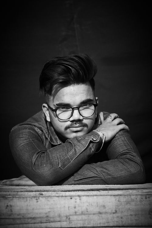 Free Black and white portrait of a young man wearing eyeglasses and denim jacket. Stock Photo