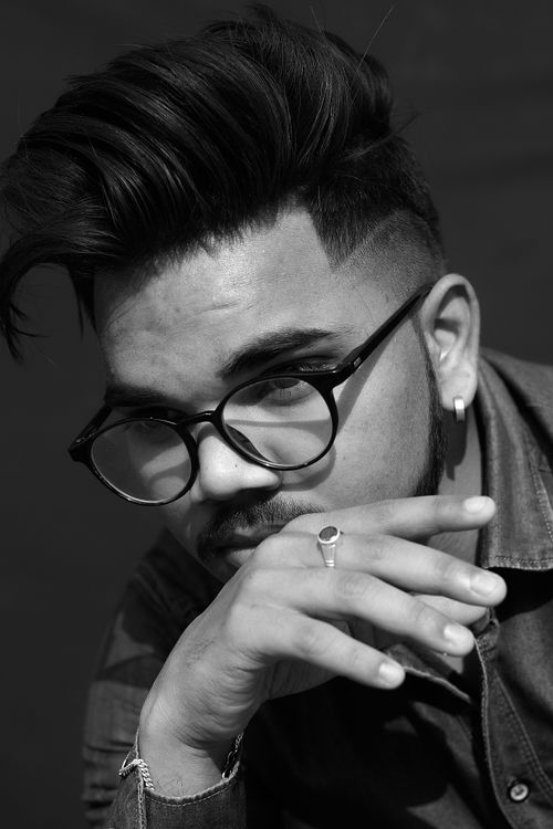 Free Close-up black and white portrait of a young man with eyeglasses and styled hair. Stock Photo