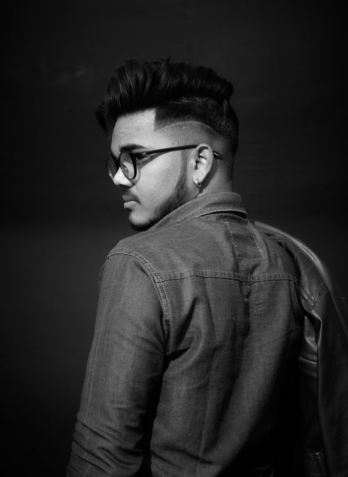 Free Black and white portrait of a stylish man with eyeglasses looking back. Stock Photo