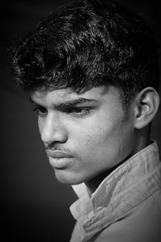 Intense black-and-white portrait of a young man, captured in monochrome style.