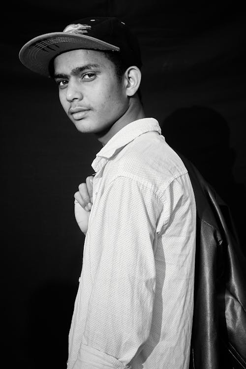 A Grayscale Photo of a Man in White Long Sleeves Looking Over Shoulder