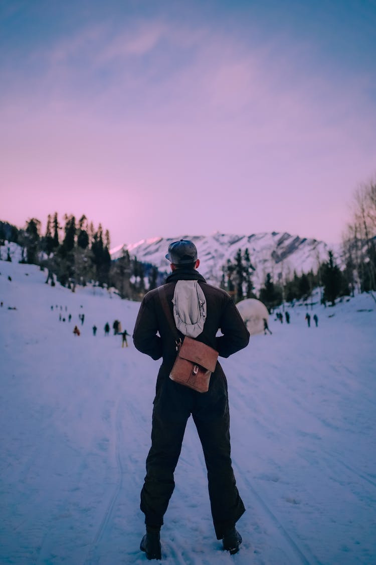 Unrecognizable Man Standing On Snowy Mountain Slope In Ski Resort