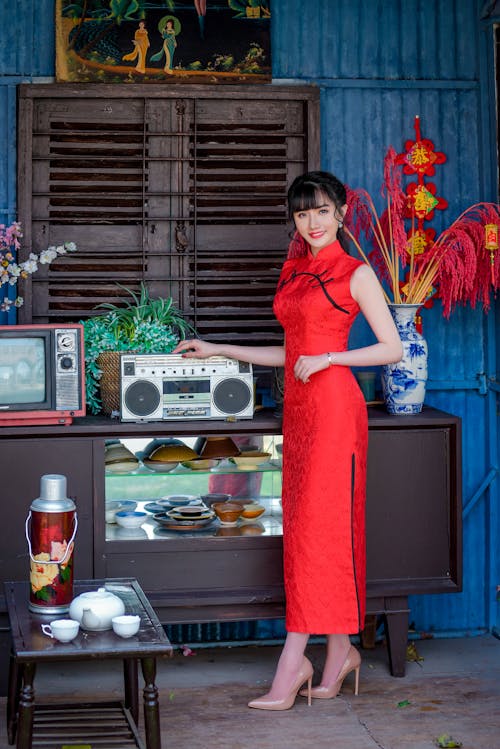 A Woman in Traditional Clothing Holding on a Cassette Player