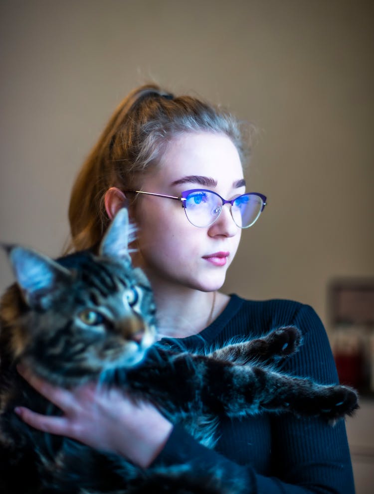 A Woman In Black Long Sleeves Holding Her Cat