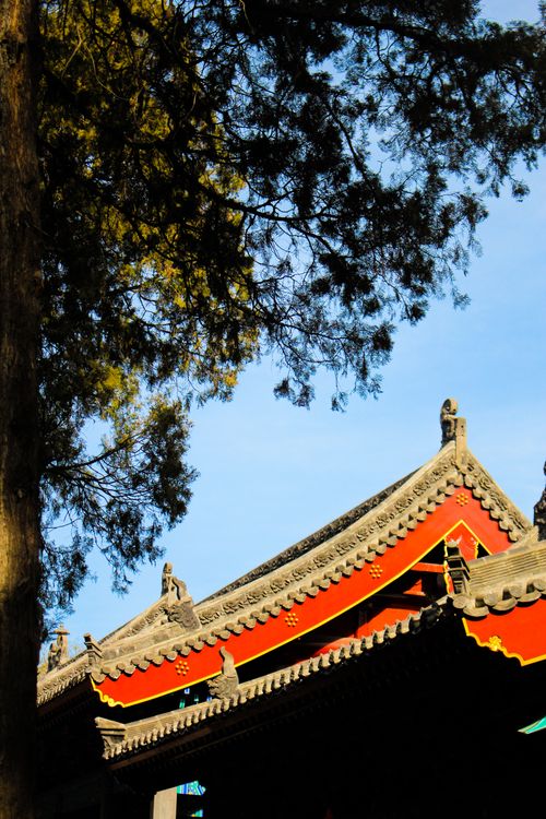 Free Traditional temple rooftop with intricate details under a clear blue sky. Stock Photo