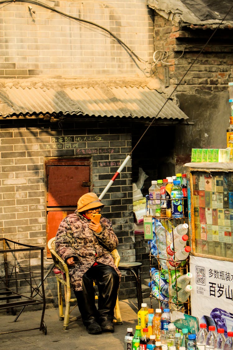 Woman Sitting Next To Outdoor Soda Stall