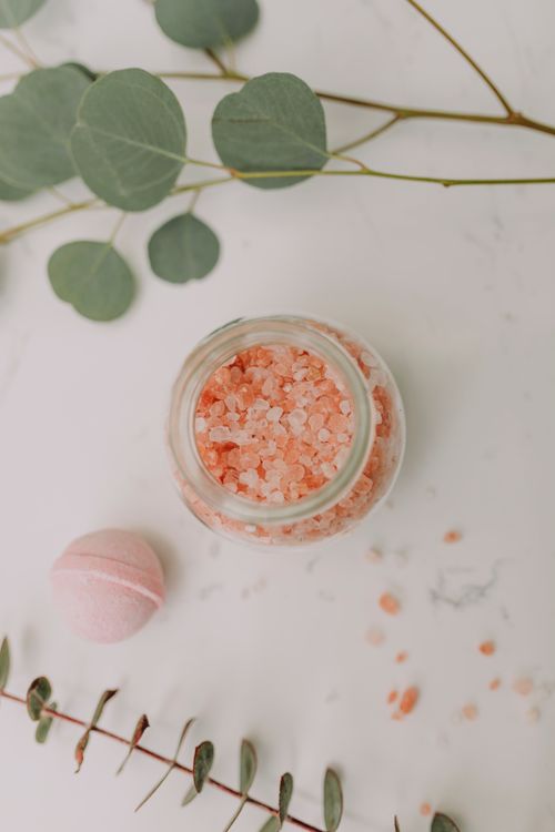 Free Aesthetic flat lay of pink bath salts and eucalyptus leaves for a relaxing spa experience. Stock Photo