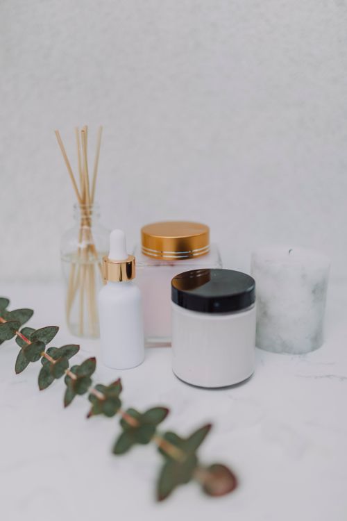Free Minimalist display of skincare products, candle, and aromatherapy sticks on a marble surface. Stock Photo