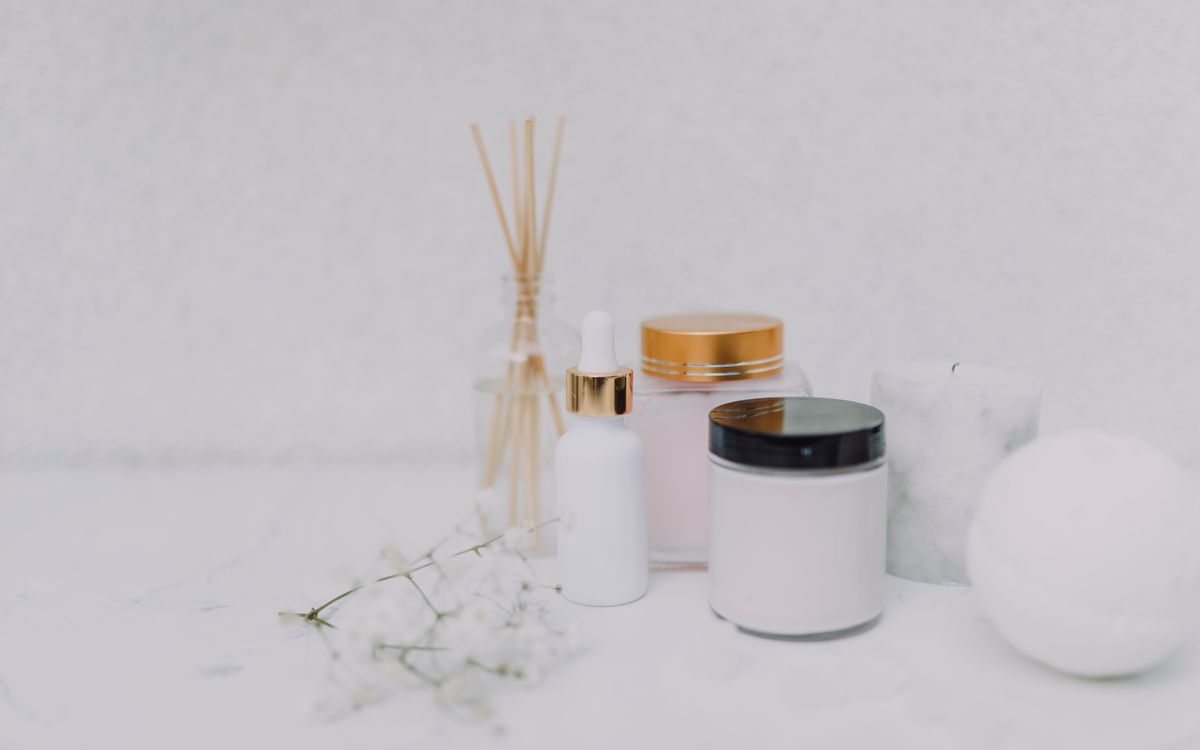 Elegant minimalistic display of skincare products and aromatherapy essentials on a clean white background.