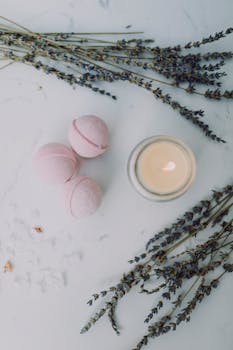 A calming spa scene featuring bath bombs, lavender sprigs, and a candle.