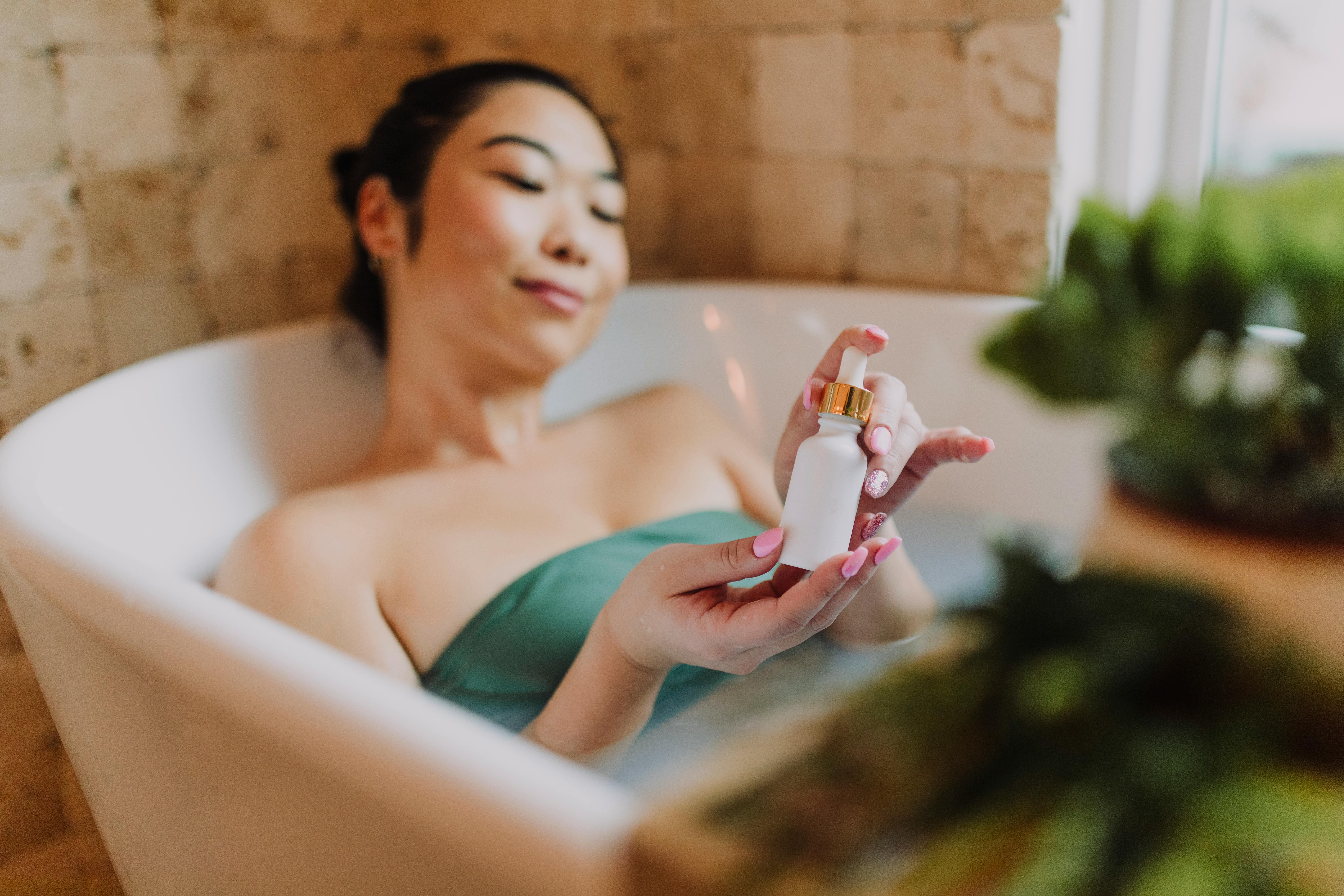 Free A Woman in the Bathtub Holding a Cosmetic Stock Photo
