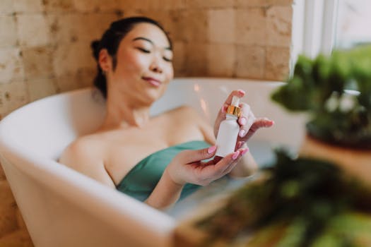 A serene woman enjoying selfcare in a bathtub, holding a cosmetic product, indoors.