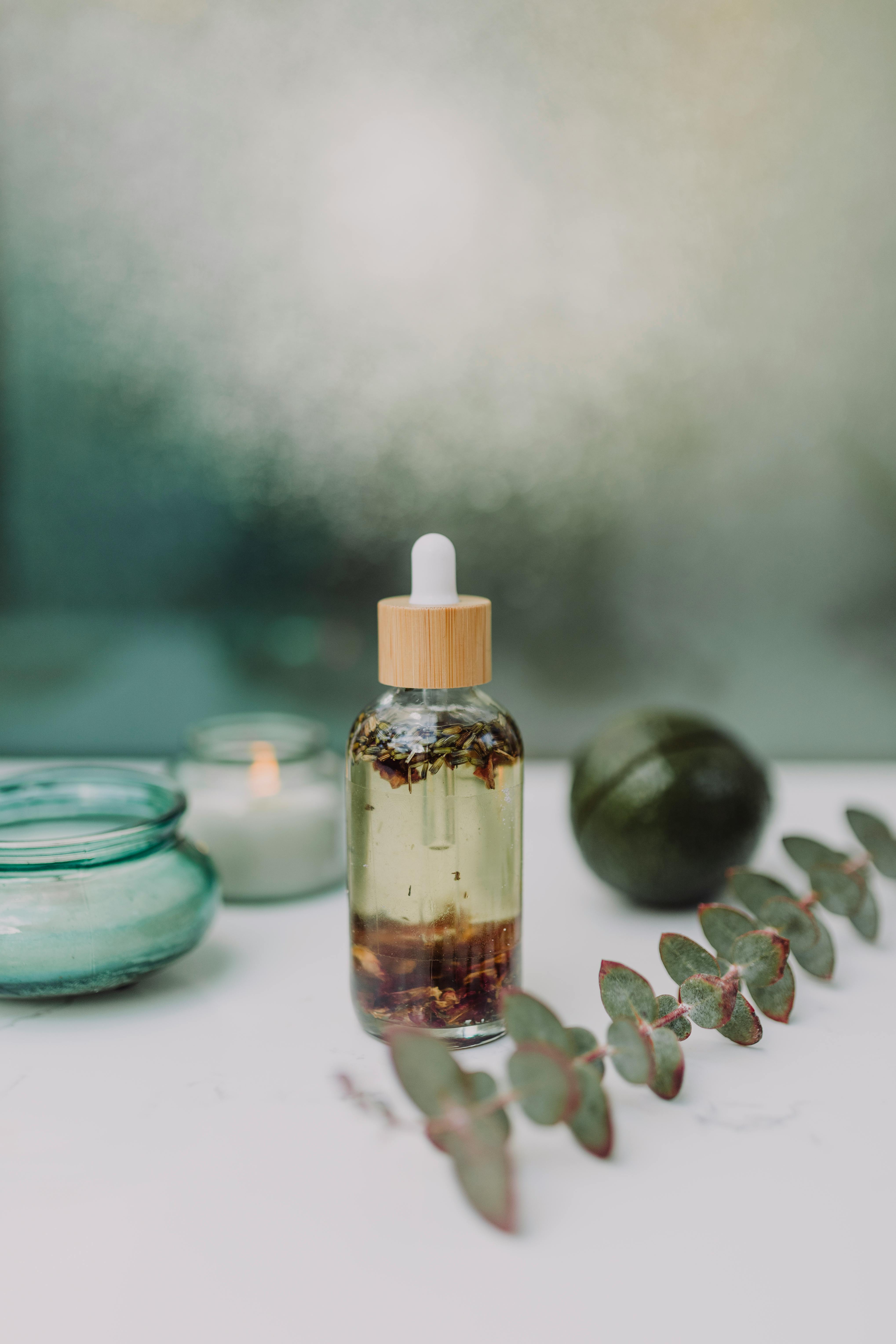 Tranquil setup of eucalyptus oil with candles and leaves for aromatherapy.
