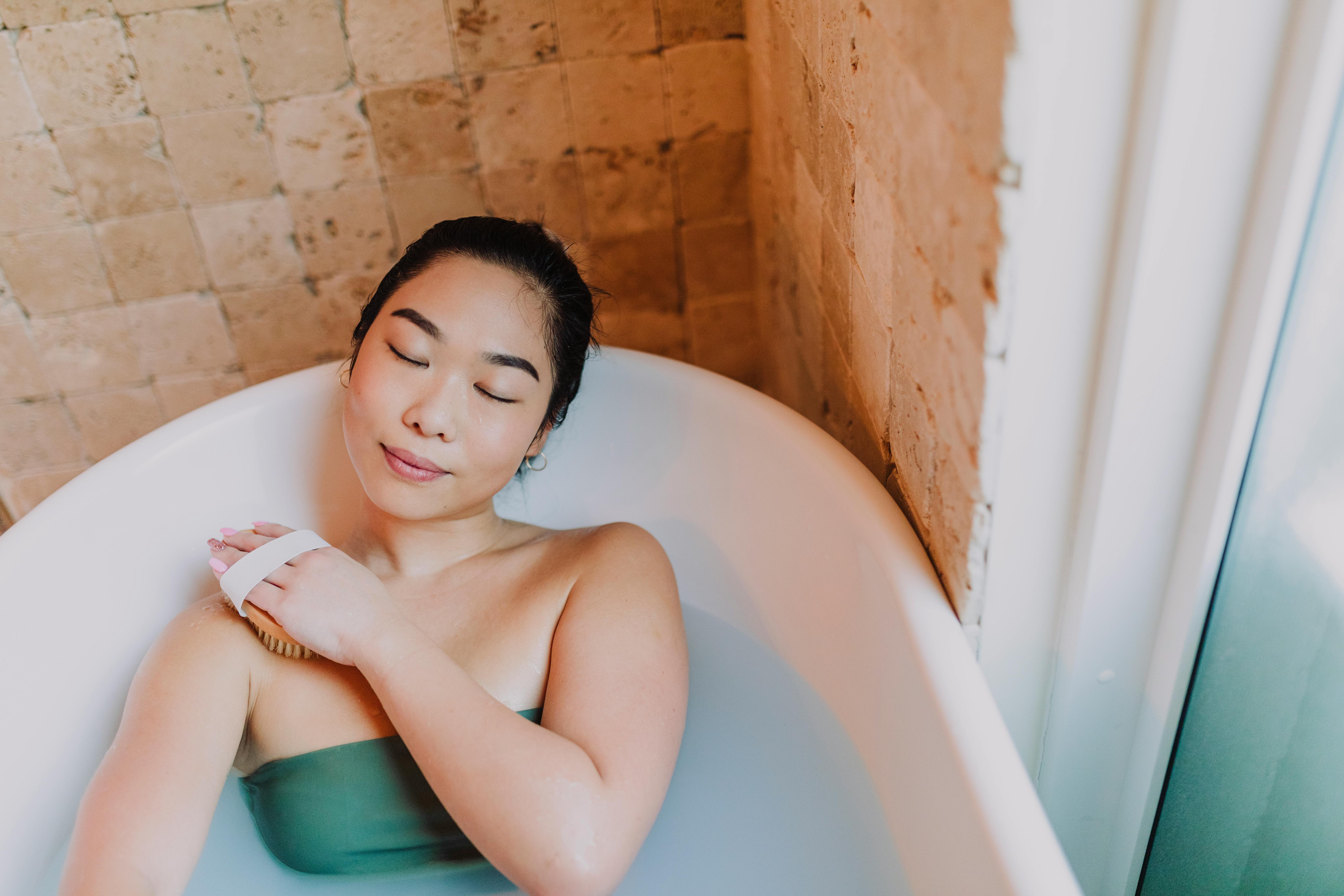 woman in green tube dress in white bathtub