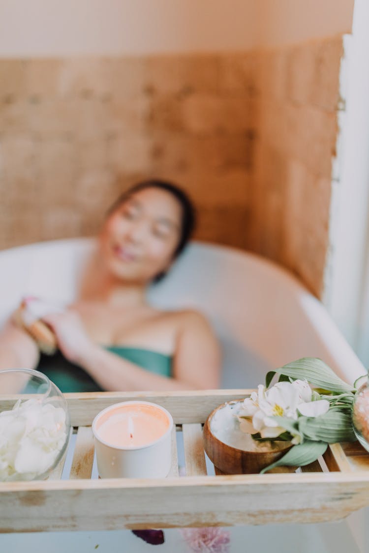 Woman Lying On A Bathtub Using A Scrub