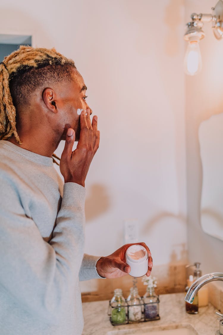 Man Applying Facial Cosmetics On His Face 