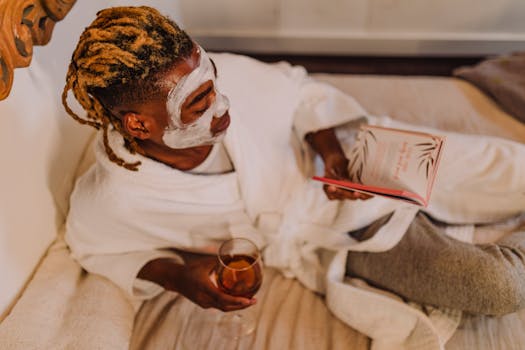 A person enjoying a spa day with a facial mask, book, and wine, embodying relaxation.