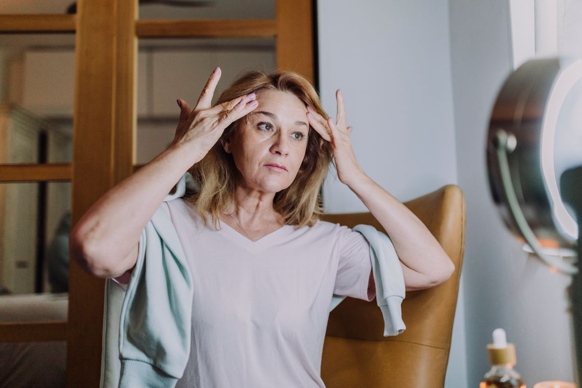 Woman performing a gentle facial massage as part of a wellness routine
