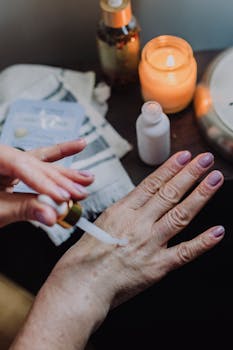 Hand applying moisturizer with a dropper, featuring soft lighting and a calming ambiance.