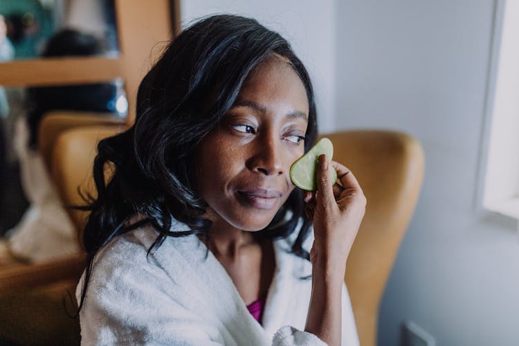 A Woman Cleaning Her Face With A Sponge